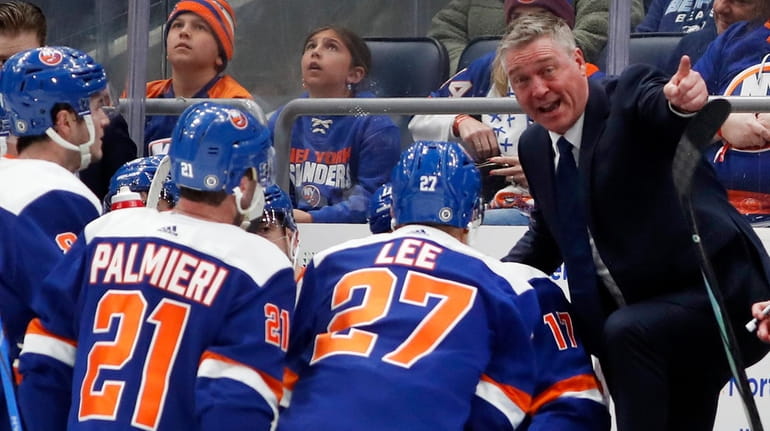 Islanders head coach Patrick Roy talks to his team during...
