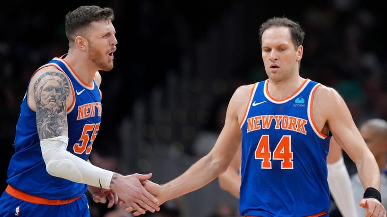 New York Knicks center Isaiah Hartenstein celebrates with forward Bojan...