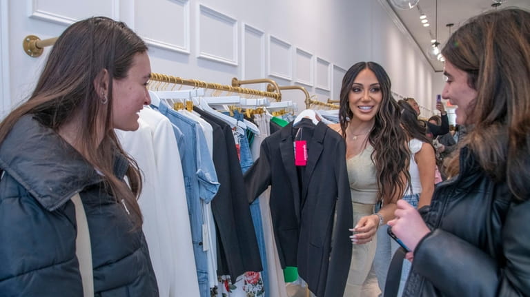 Melissa Gorga helps customers at the opening of Envy in...