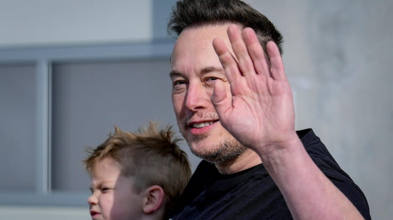 Tesla CEO Elon Musk waves as he leaves the Tesla...