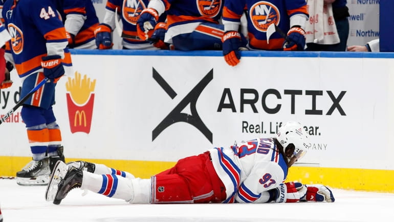 Mika Zibanejad of the Rangers lays on the ice during the...