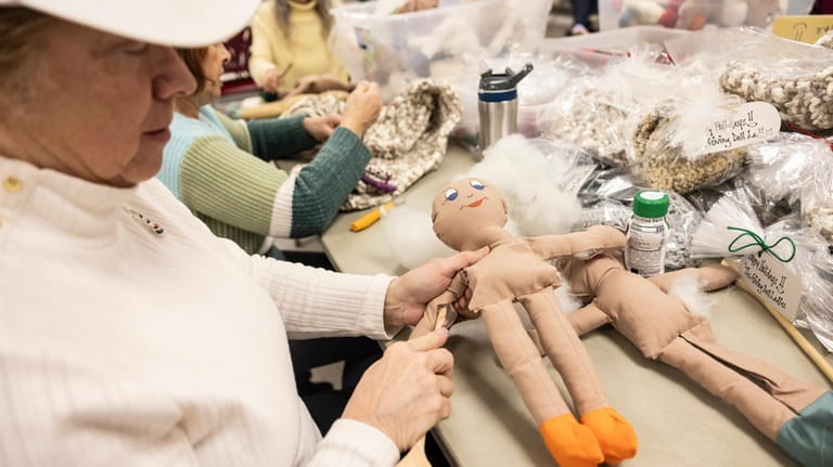 Volunteer Sue Kubelle stuffs a doll at the New York Giving...