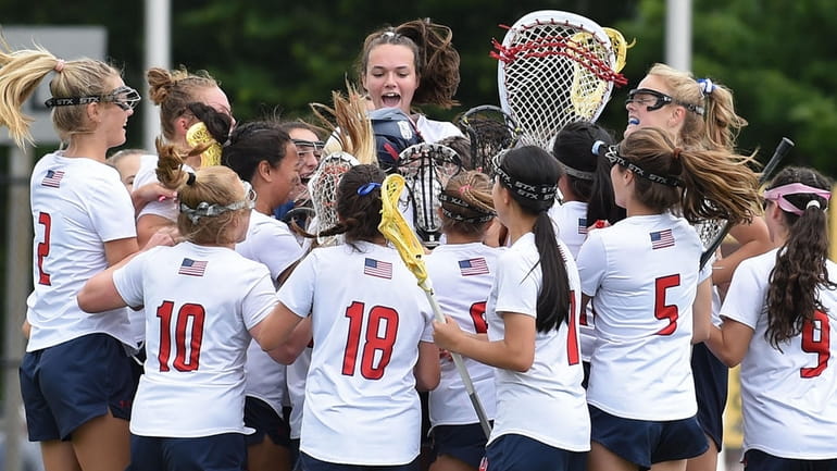 Cold Spring Harbor girls lacrosse teammates celebrate after their victory...