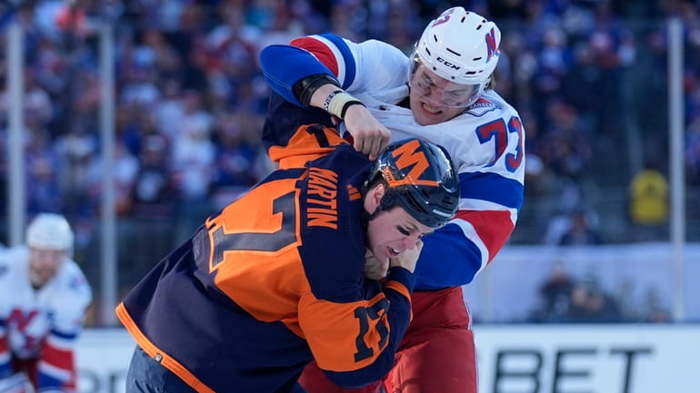 The Rangers' Matt Rempe, top, fights with the Islanders' Matt Martin...