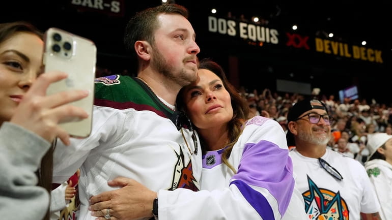 Arizona Coyotes season-ticket holders comfort one another as time expires...