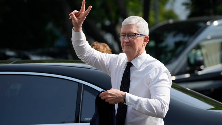 Apple CEO Tim Cook gestures upon the arrival for a...