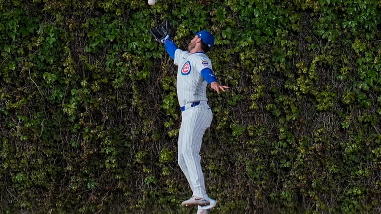 Chicago Cubs center fielder Cody Bellinger struggles to catch a...