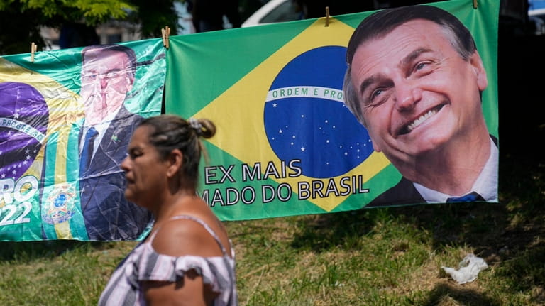 A woman walks past a banner featuring the Brazilian national...
