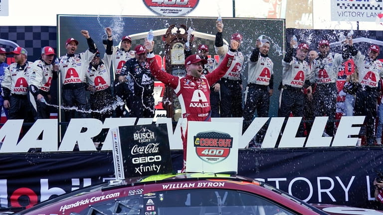 William Byron celebrates in Victory Lane after winning a NASCAR...
