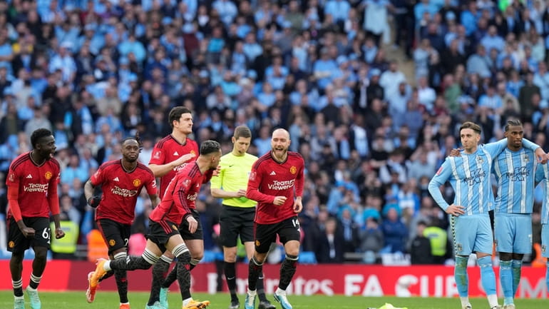 Manchester United players react during a penalty shootout at the...