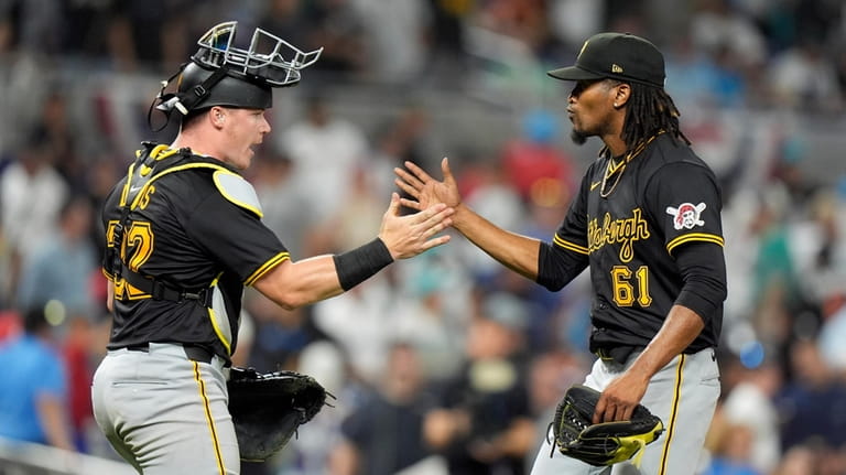Pittsburgh Pirates catcher Henry Davis (32) and relief pitcher Jose...