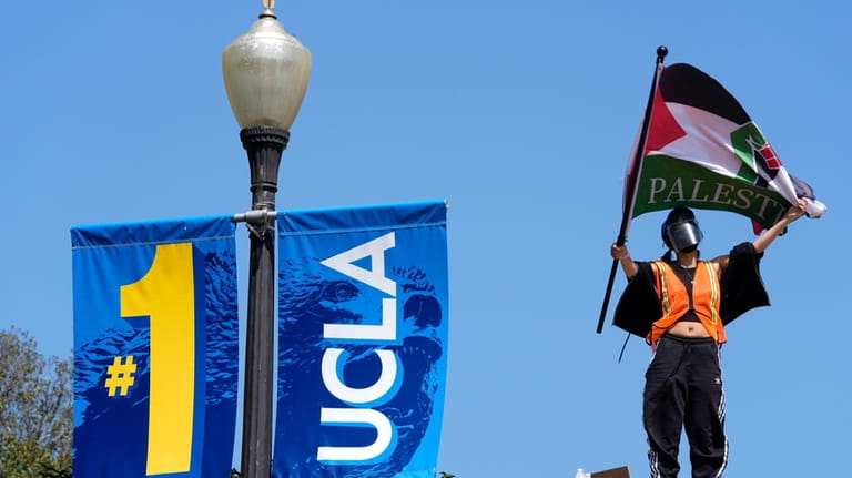 Demonstrators wave flags on the UCLA campus, after nighttime clashes...