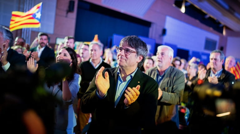 Former regional president Carles Puigdemont applauds during a campaign rally...