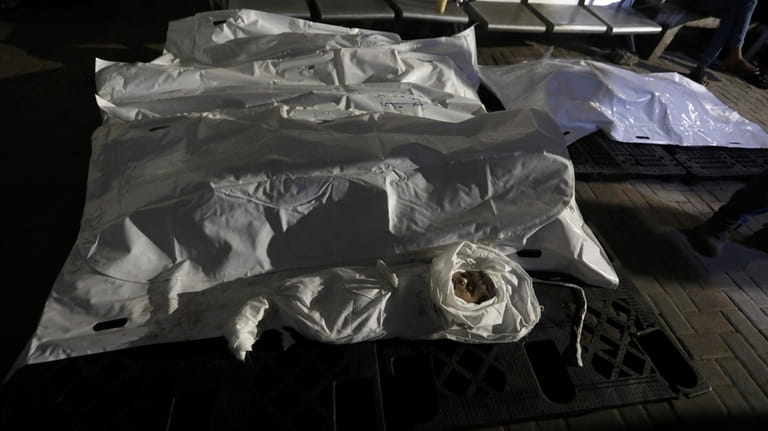 The Qeshta family is seen in body bags at the...