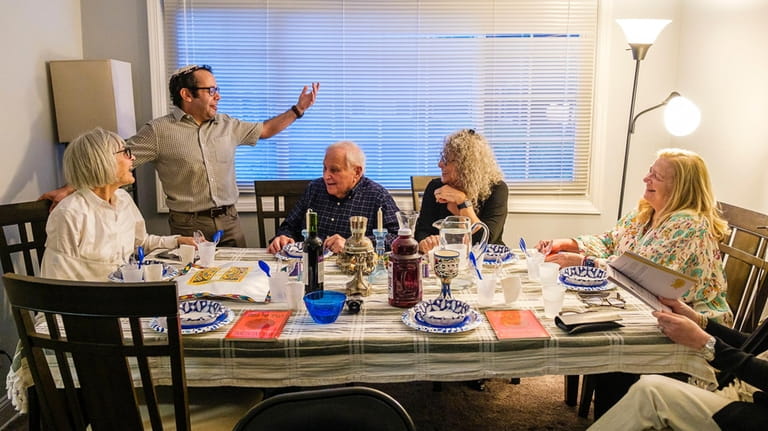 Host Jonah Sanderson (standing) chats with guests during a recent Passover...