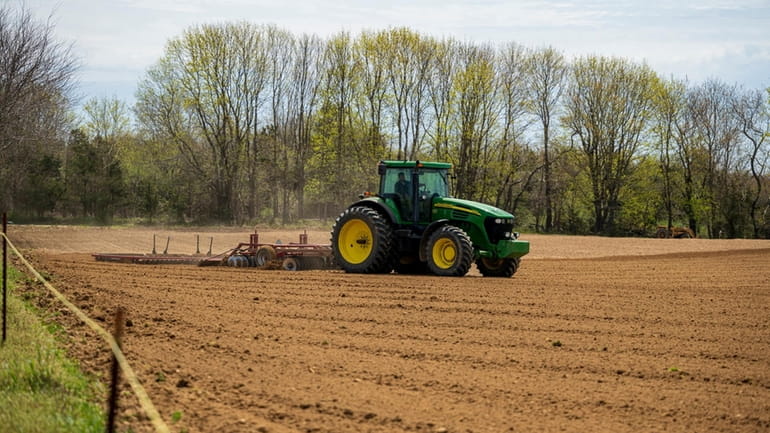 A tractor tills soil on a farm along Edwards Avenue...