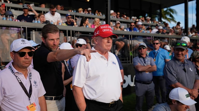 Republican presidential candidate former President Donald Trump, center, and son...