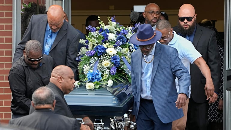 Pallbearers carry the casket of Frank Tyson out of Hear...