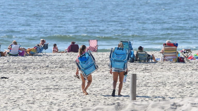 Two women head to the beach at Gilgo Beach as...