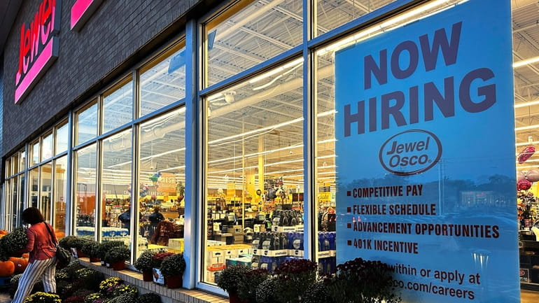 A hiring sign is displayed at a grocery store, Oct....