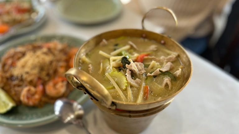 Green curry with pork and vegetables served in a golden...