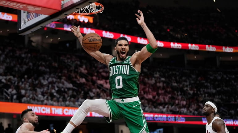 Boston Celtics forward Jayson Tatum (0) dunks between Cleveland Cavaliers...