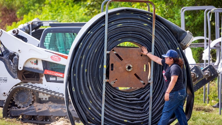 Crews lay out miles of flexible pipeline to help supply...