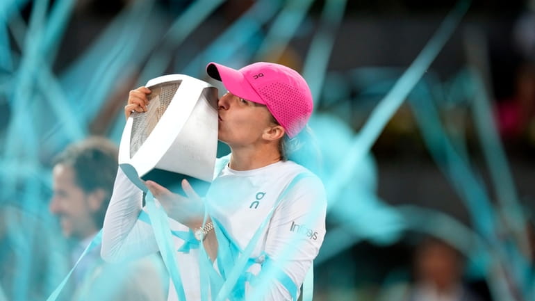 Poland's Iga Swiatek kisses the trophy after winning the women's...