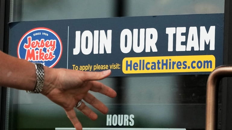 A hiring sign is displayed at a restaurant in Glenview,...