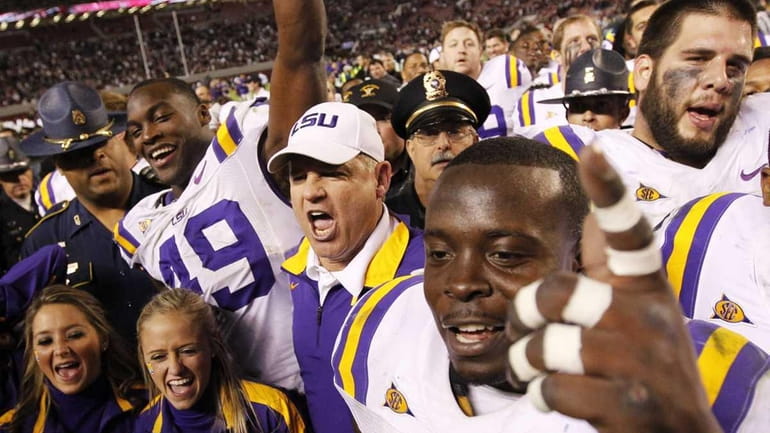 LSU head coach Les Miles celebrates with his team after...