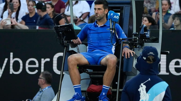 Serbia's Novak Djokovic sits in the umpires chair after defeating...