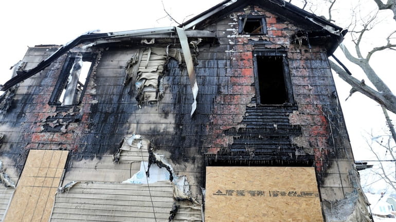 The burned-out shell of a two-story house is quiet, Monday,...