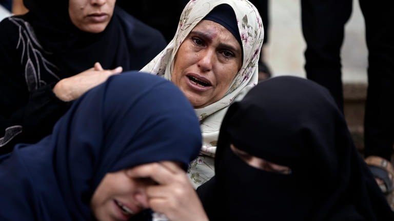 Palestinians mourn relatives killed in the Israeli bombardment of the...