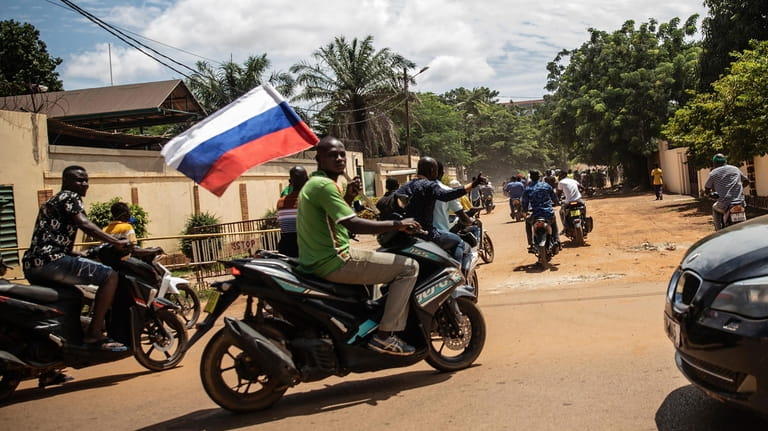 Supporters of Capt. Ibrahim Traore parade wave a Russian flag...