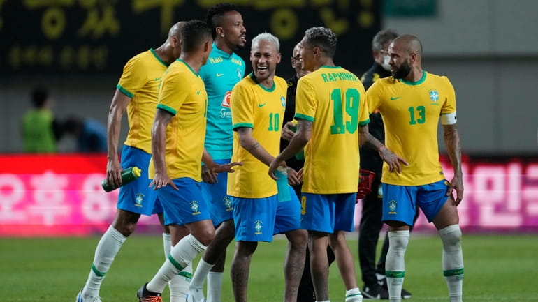 Brazil's Neymar, center, celebrates with his teammates after defeating South...