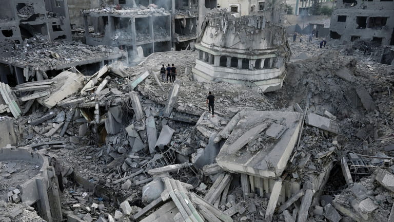 Palestinians inspect the rubble of the Yassin Mosque destroyed after...