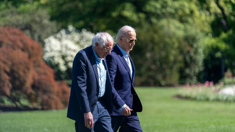 President Joe Biden, right, and Sen. Bernie Sanders, I-Vt., walk...