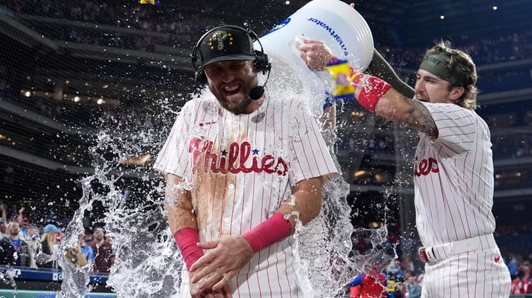 Philadelphia Phillies' Kody Clemens, center, is doused by Bryson Stott...