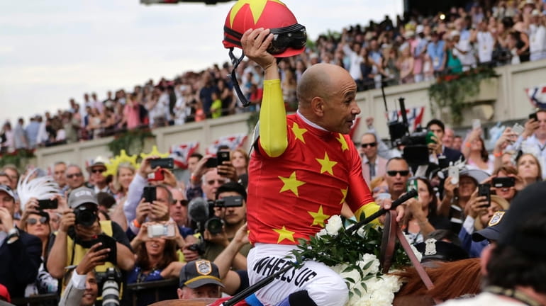Jockey Mike Smith tips his helmet to the crowd as...