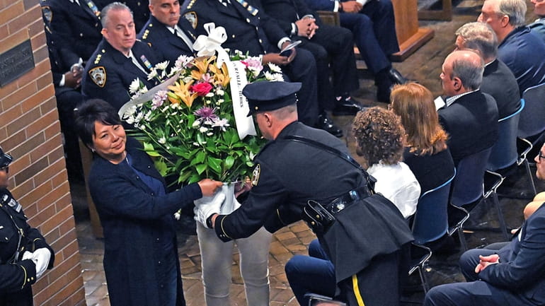 A bouquet of flowers is presented to an NYPD officer...