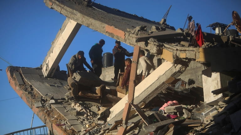 Palestinians inspect the damage of a destroyed house following Israeli...