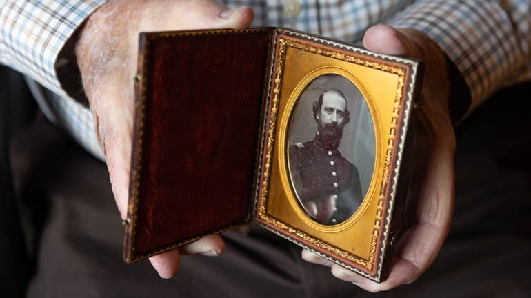 Robert Farrell holds a photo of Capt. Sylvester Nicholl of...