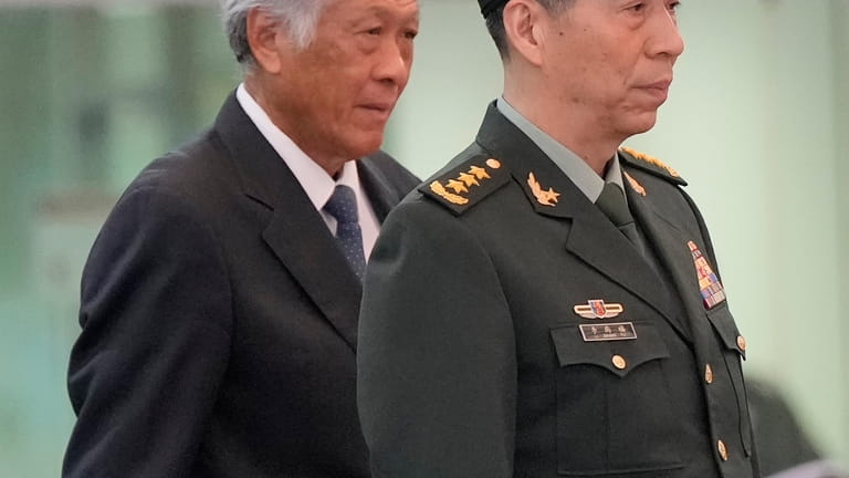 Chinese Defense Minister Gen. Li Shangfu, right, stands with Singapore...