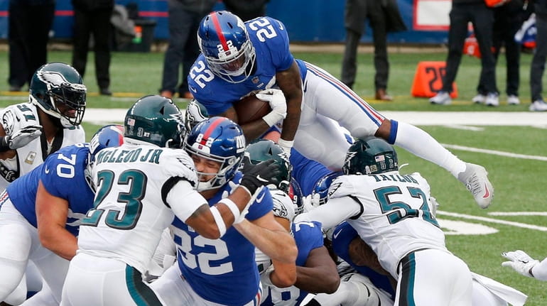 Wayne Gallman #22 of the Giants goes up and over into...