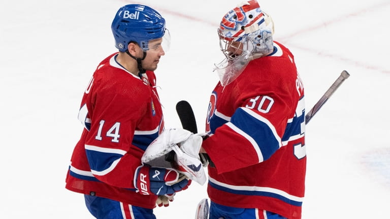 Montreal Canadiens goaltender Cayden Primeau (30) hands teammate Nick Suzuki...