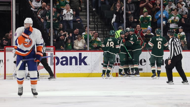 Minnesota Wild center Connor Dewar (26) is surrounded by teammates...