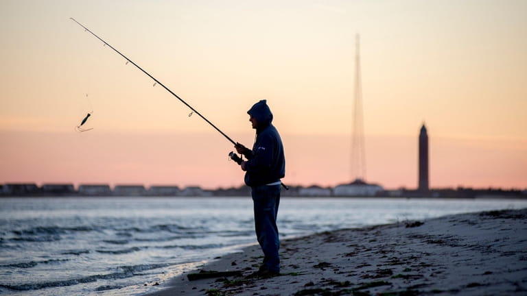 Jeff Dean, of West Islip, casts off on the shores...