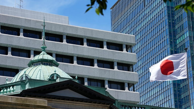 A Japanese flag flutters at the Bank of Japan headquarters...