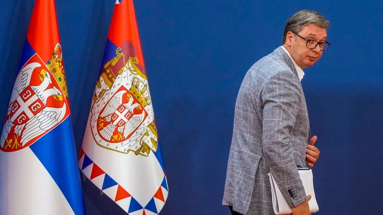 Serbian President Aleksandar Vucic leaves after a press conference in...