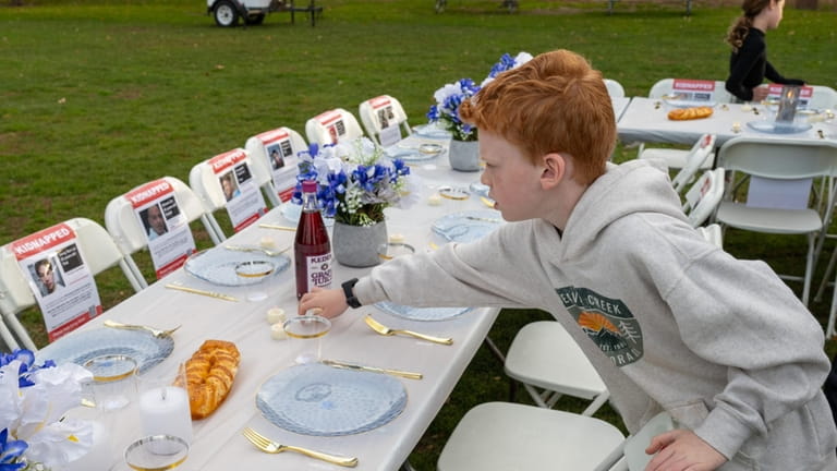 Jesse Feiner, 9, placing candle on table at Blumenfeld Family...